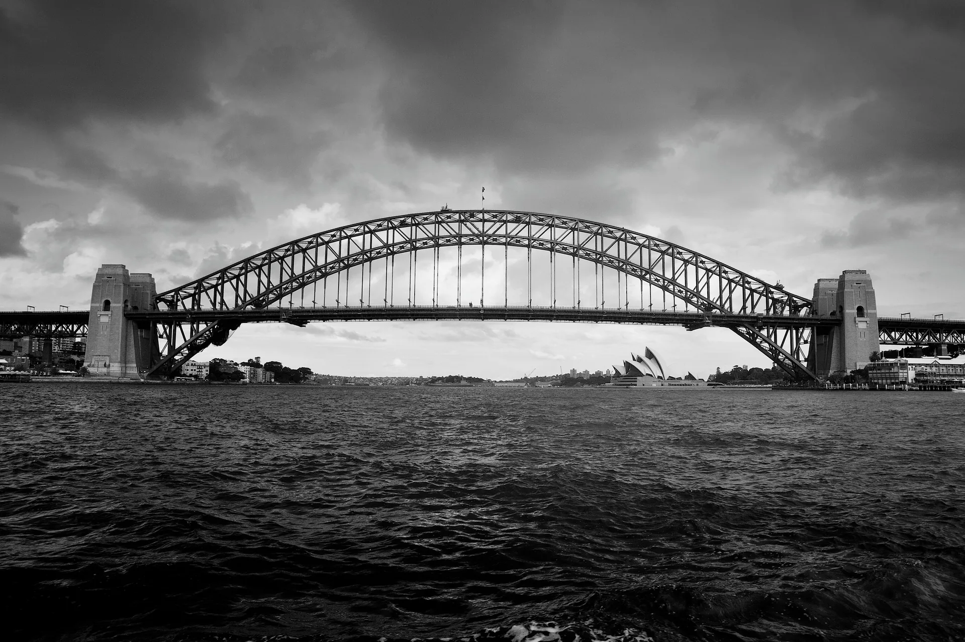 Sydney Harbour Bridge beneath storm clouds in black and white